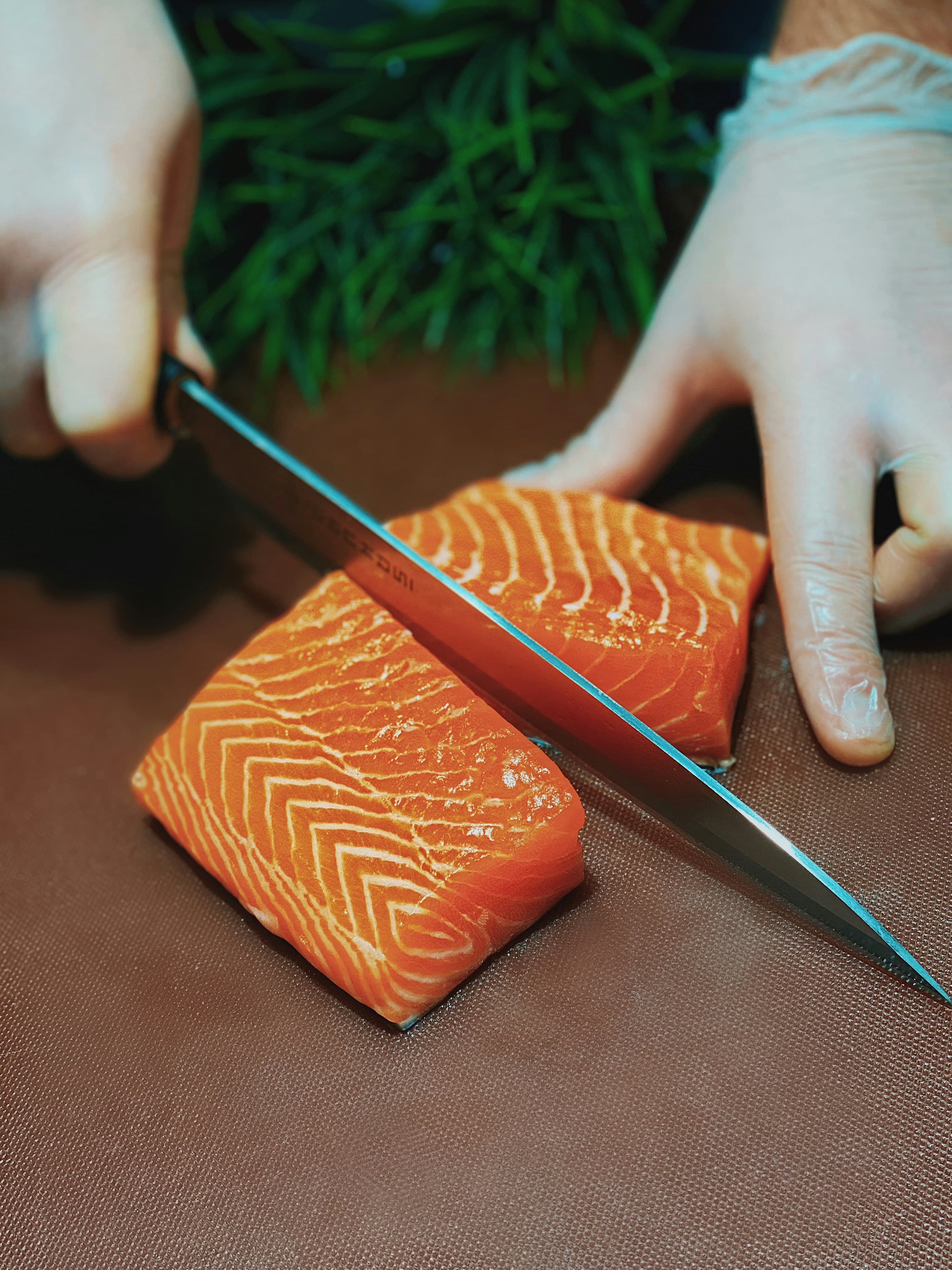 Chef slicing fresh fish for sushi